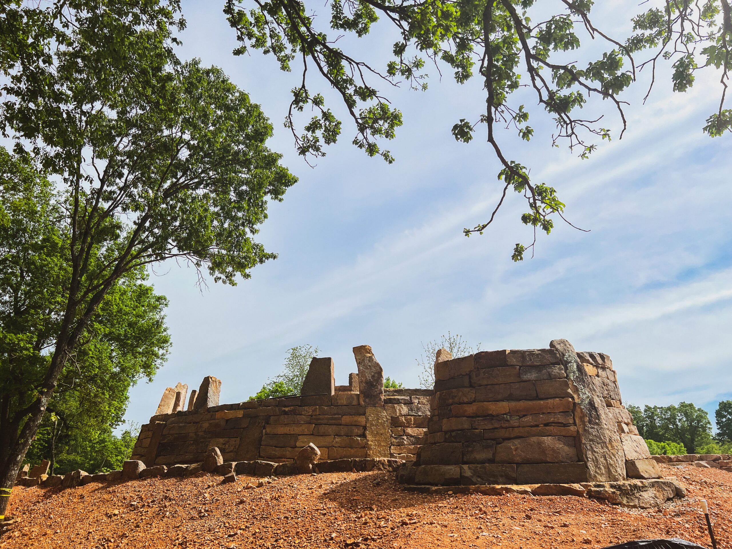 A castle structure being built with stone, rocks, and dirt.